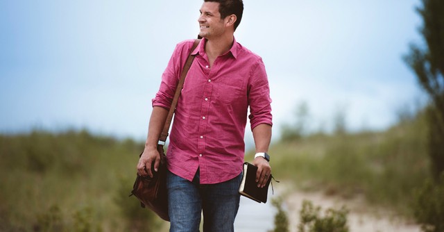 Man walking on path with a Bible