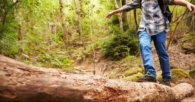 Boy balancing as he walks across a log