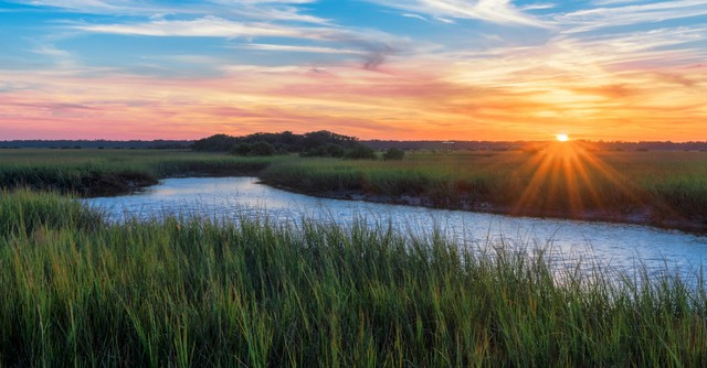Sunset over a beautiful river in a meadow