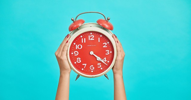 A woman holding up a clock