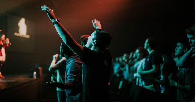 Young man with hands raised in worship