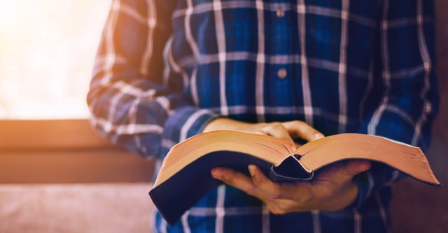 Man holding an open Bible