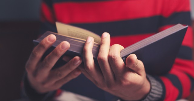 Boy holding an open Bible
