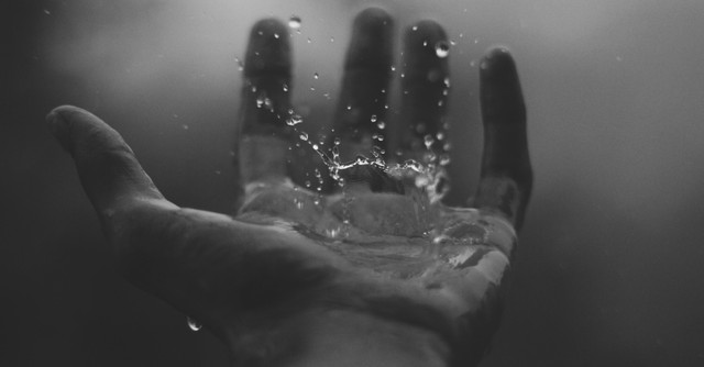 Rain dropping on a person's hand