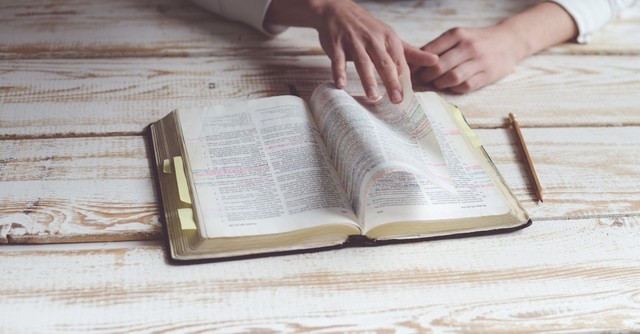 Woman turning the pages of the Bible