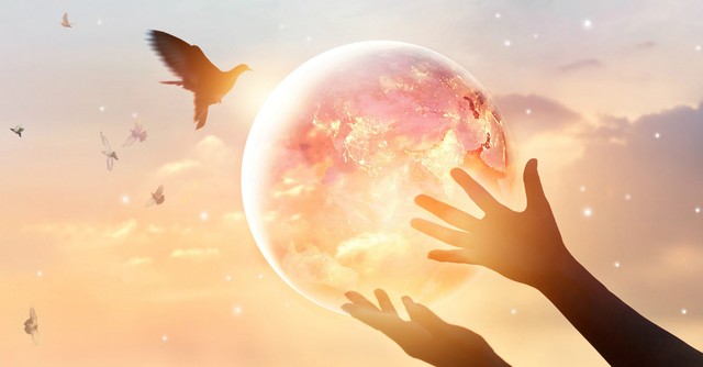 Woman holding glowing globe as a dove flies by - new heaven new earth