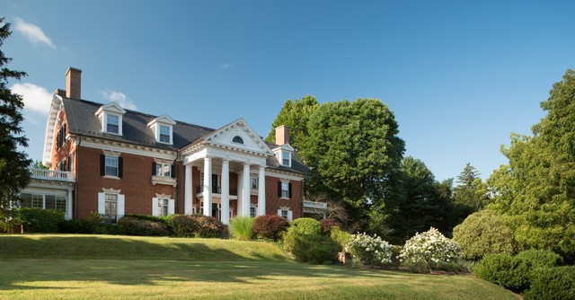 Large mansion with manicured gardens out front
