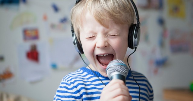 Young boy yelling into a microphone