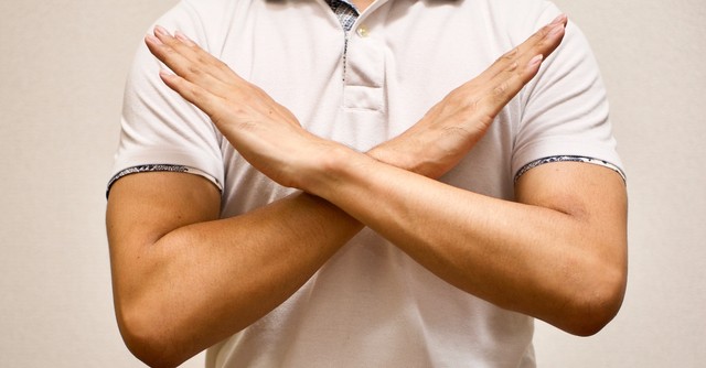 Arms held up in an X