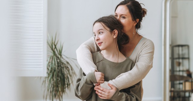 Mom and teen daughter hugging
