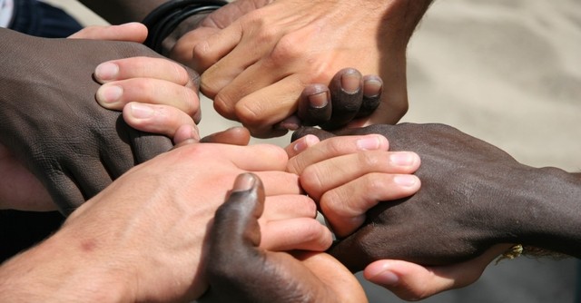 Caucasian and african american hands held together