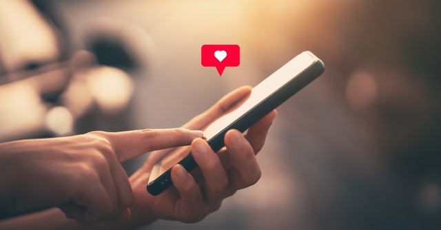 Finger pressing the like heart on a cell phone