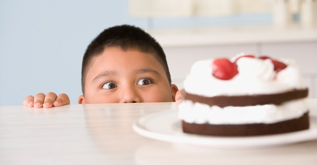 Boy being tempted by a cake on the counter