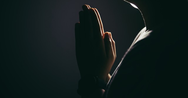 praying hands in the dark