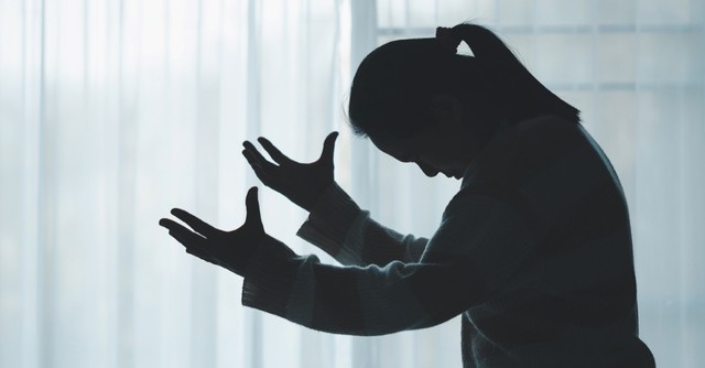 silhouette of distressed woman praying, fervent prayer
