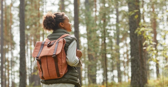woman walking outside, joyfully looking up at the sky