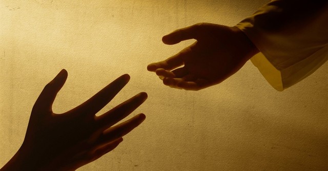 One hand reaching down to help another