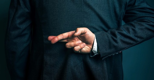 man with fingers crossed, lying