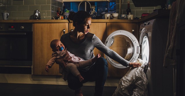 Tired stressed mom with a baby doing chores