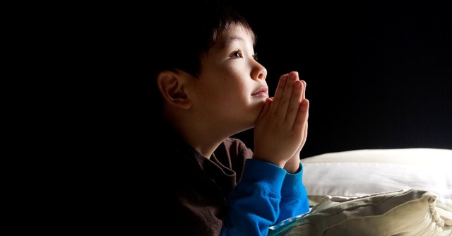 Little boy praying before bed