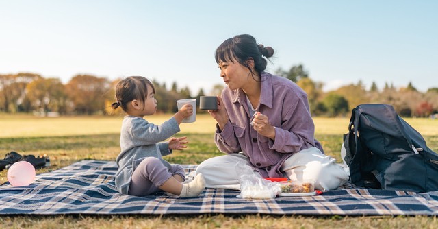 Mom and toddler daughter having a picnic
