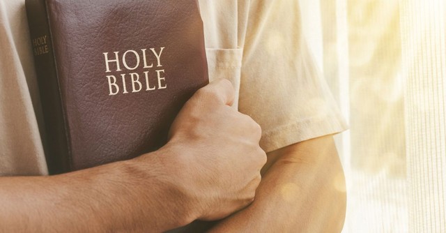 Man holding a Bible;