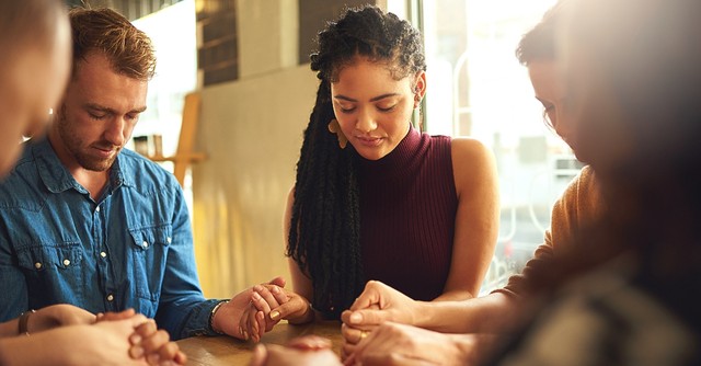 People praying around a table