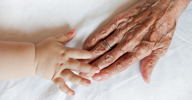 An old person's hand and a baby's hand