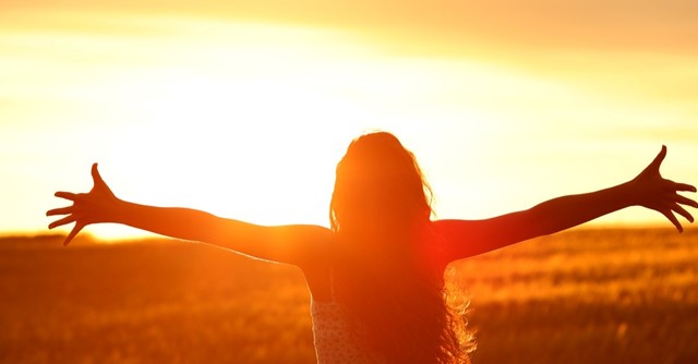woman worshipping god outside bright sunlit background