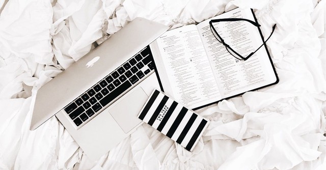 Bible, journal, laptop, and glasses