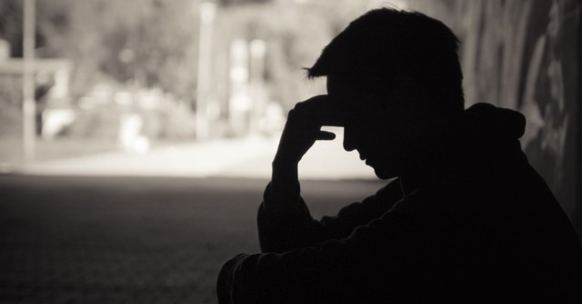 silhouette of stressed man sitting under tree, signs of the end times