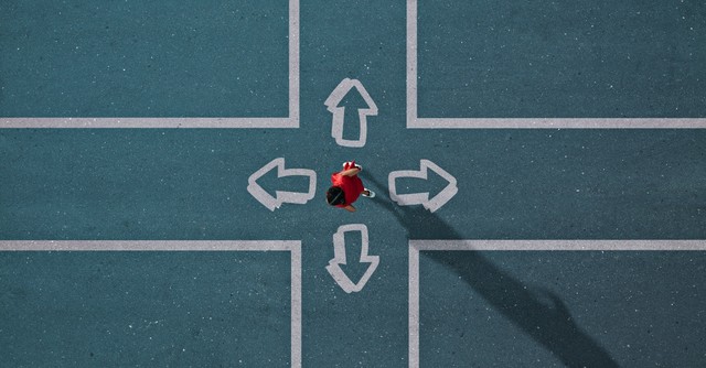 Person standing at a 4-way cross, with arrows pointing in each direction