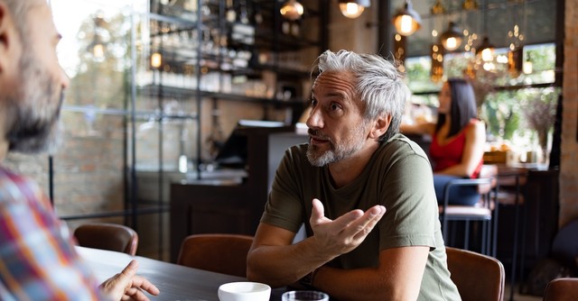 Man talking with a friend in a coffee shop