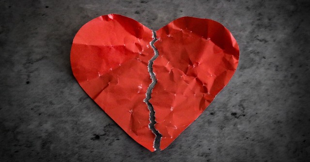 Crumpled paper heart torn in half
