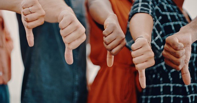 A group of people with their thumbs down