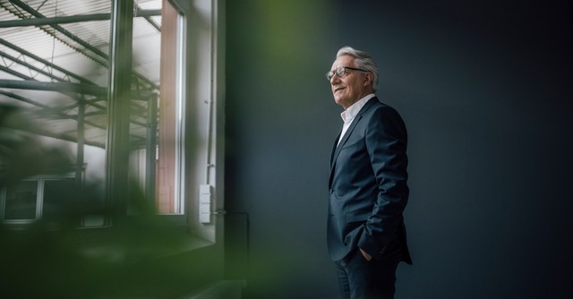 Senior businessman looking out a window, happy