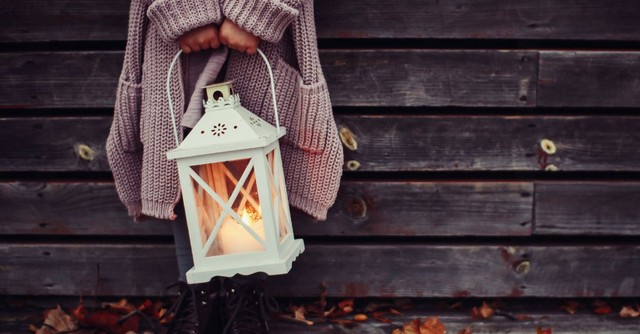 Woman holding a lantern outside in Autumn