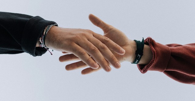 Two people reaching out to shake hands