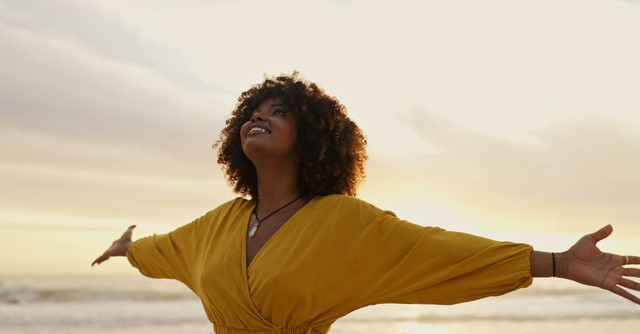 Woman giving God praise at sunset outside