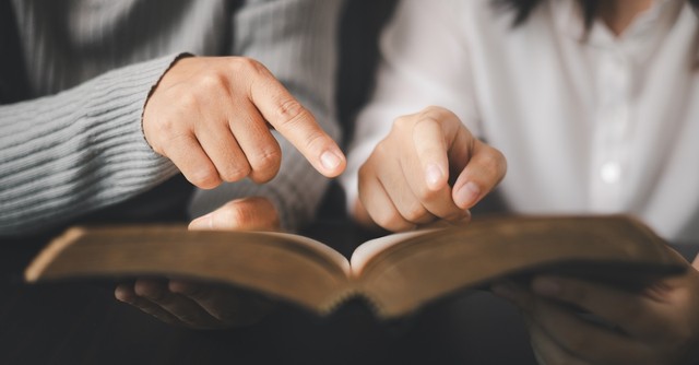 Parent and teen reading Bible study together