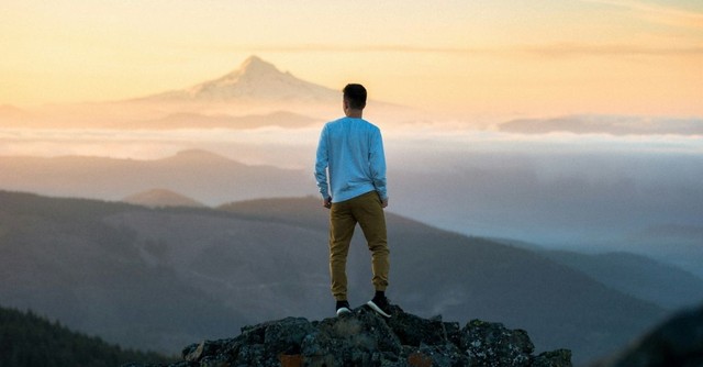 Man standing atop a mountain