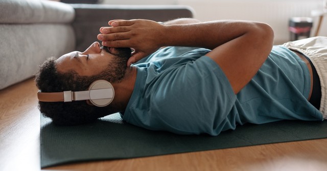 Man doing yoga meditation headphones listening to music