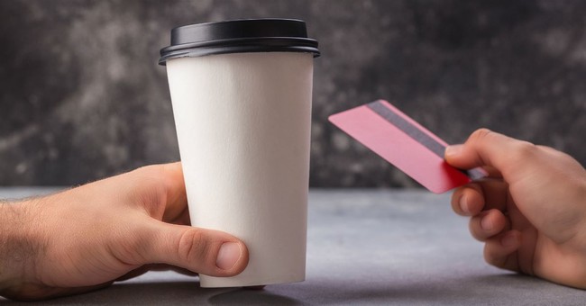 man's hand holding disposable coffee cup, girl's hand holding credit card