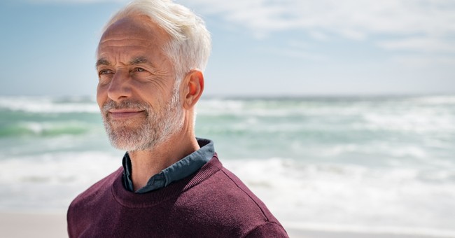 senior man looking thinking at beach