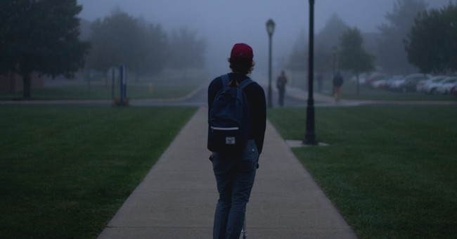 young man with backpack standing in dark fog on college campus, affirmations for parents of prodigal child