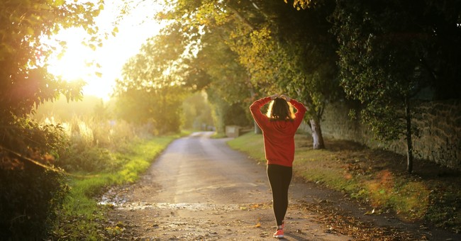 Woman walking towards the sunrise