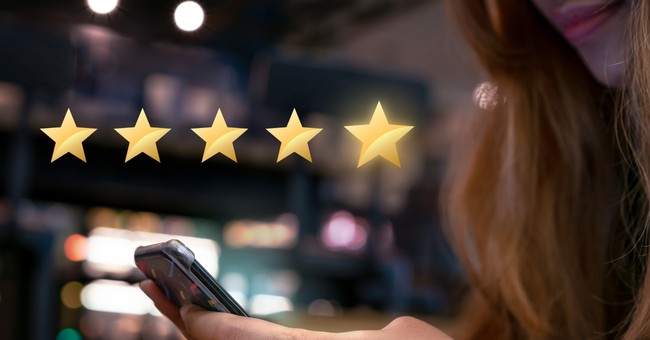 woman on smartphone pressing five gold stars