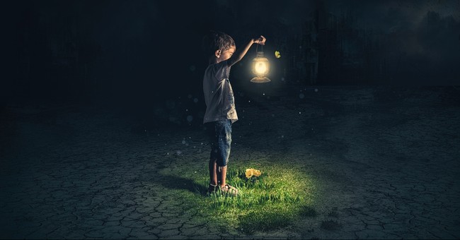Boy holding a lantern in the dark