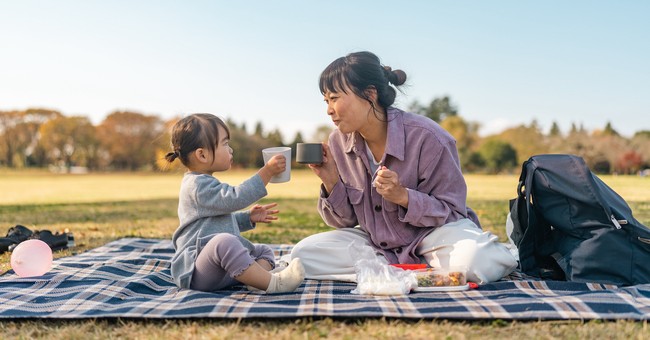 Mom and toddler daughter having fall picnic