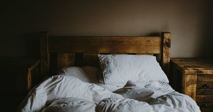 Bible, prayer and black woman praying on bed in bedroom home for